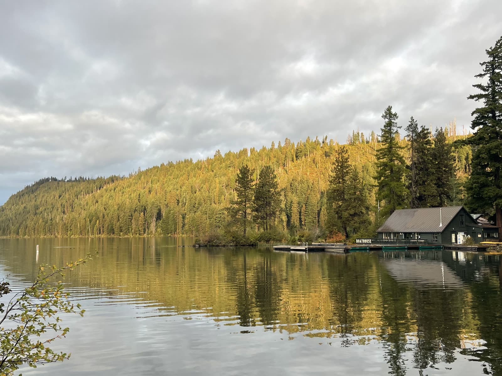 Morning light on Suttle Lake with the boathouse and pine ridge reflected