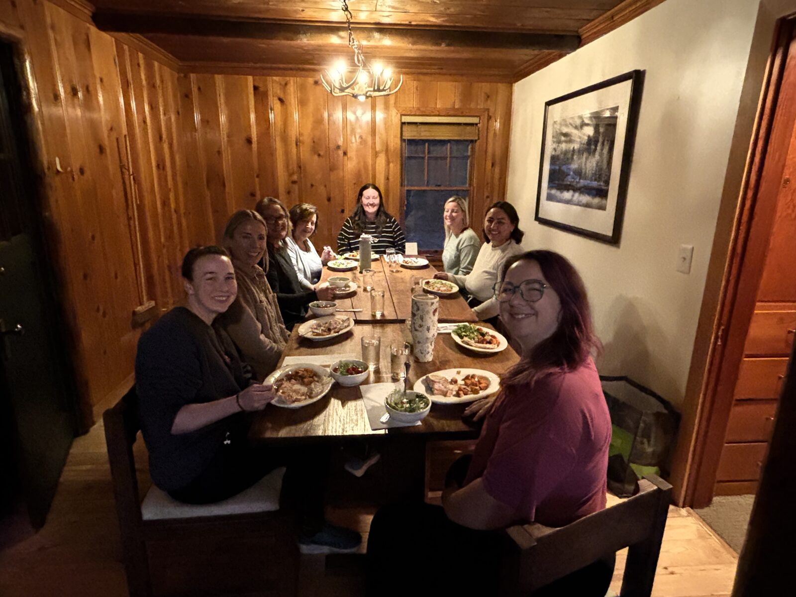 Retreat guests around the table for a chef-prepared dinner at the lodge