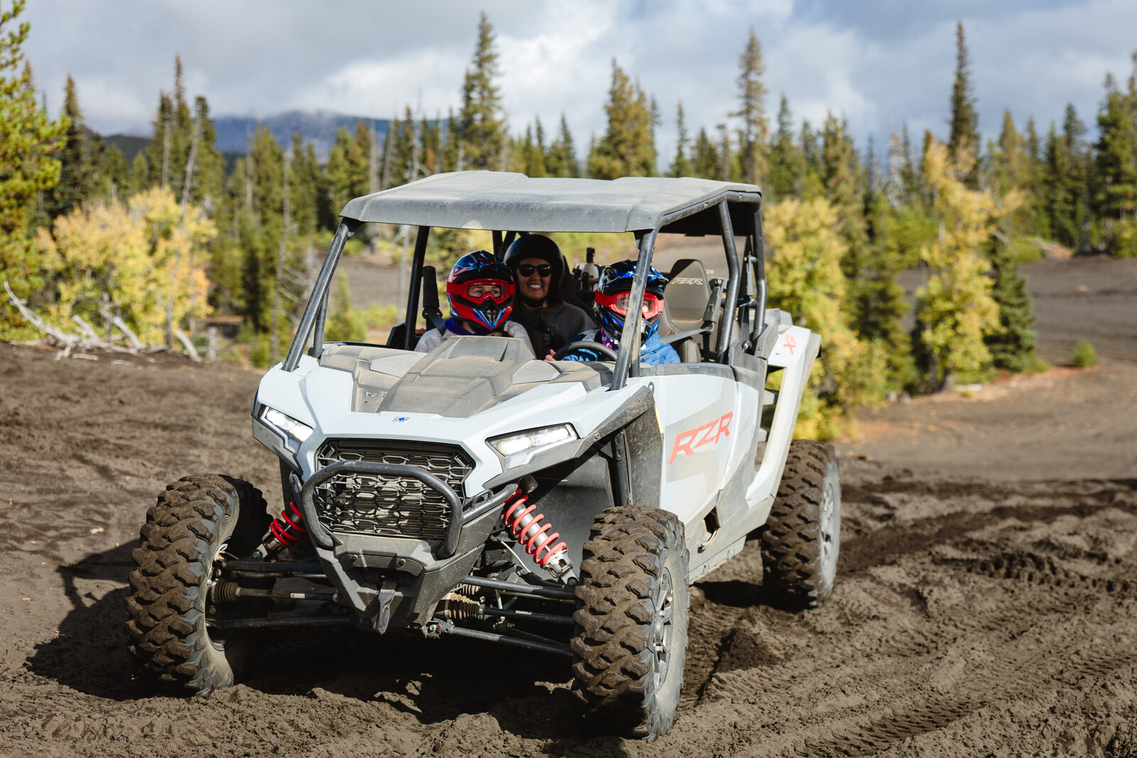 Retreat guests riding a side-by-side ATV on the Black Sands trail